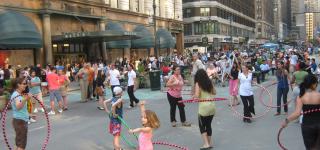 Multiple people in Hearld Square Hula Hooping. 