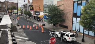 A birds eye view photo of Hillel Place looking towards Flatbush Ave. The area between Kenilworth Pl and Flatbush Ave is closed off from traffic and you can see markings indicating where the new curb and street markings will be by Kenilworth Pl.