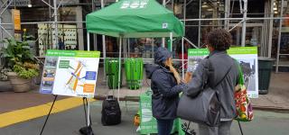 An action photo of a Street Ambassador conducting a survey with a local at Greeley Square.