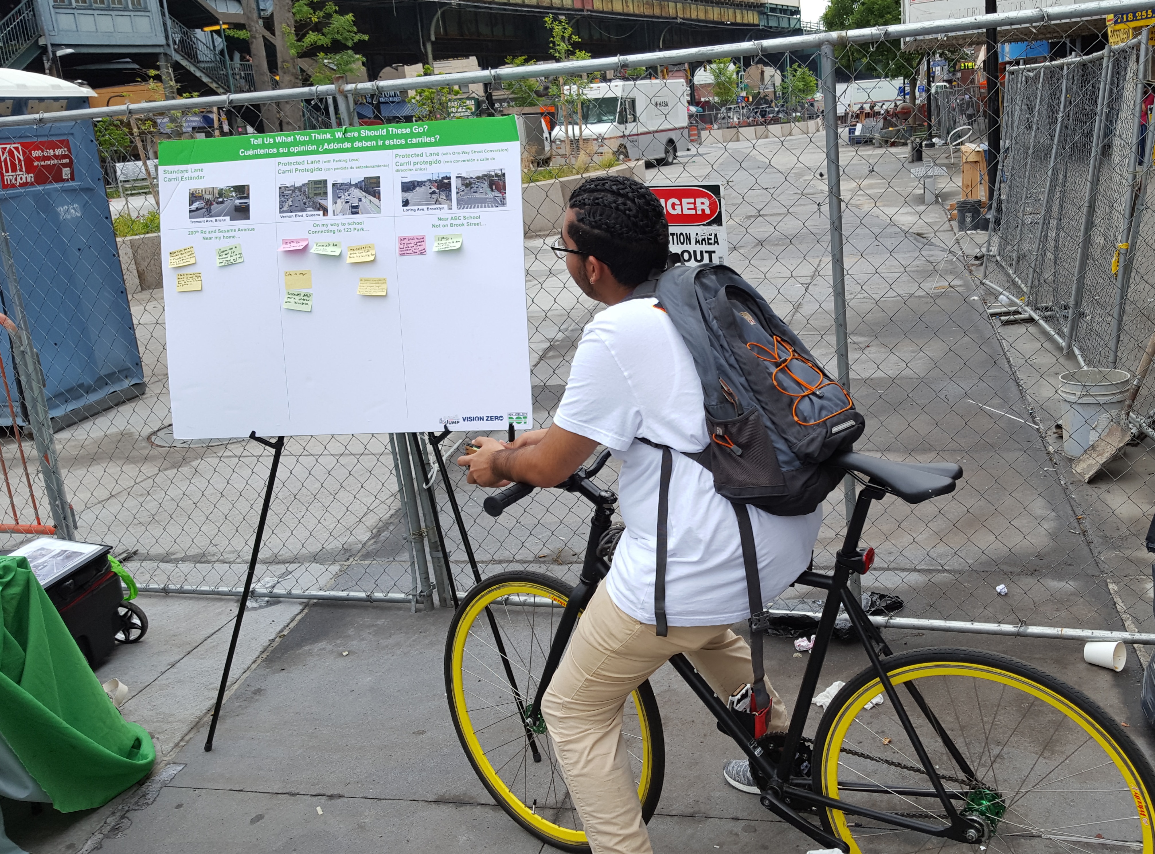 Cyclist looking up reading a board