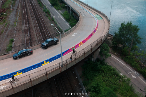Depot Place in the Bronx shown from an aerial angle, with a colorful mural along a two-way bike lane along the Harlem River