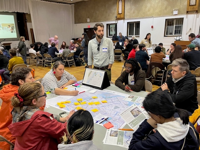 A small group discusses comments regarding the Queens Waterfront Greenway with DOT staff at an October 2024 public workshop.