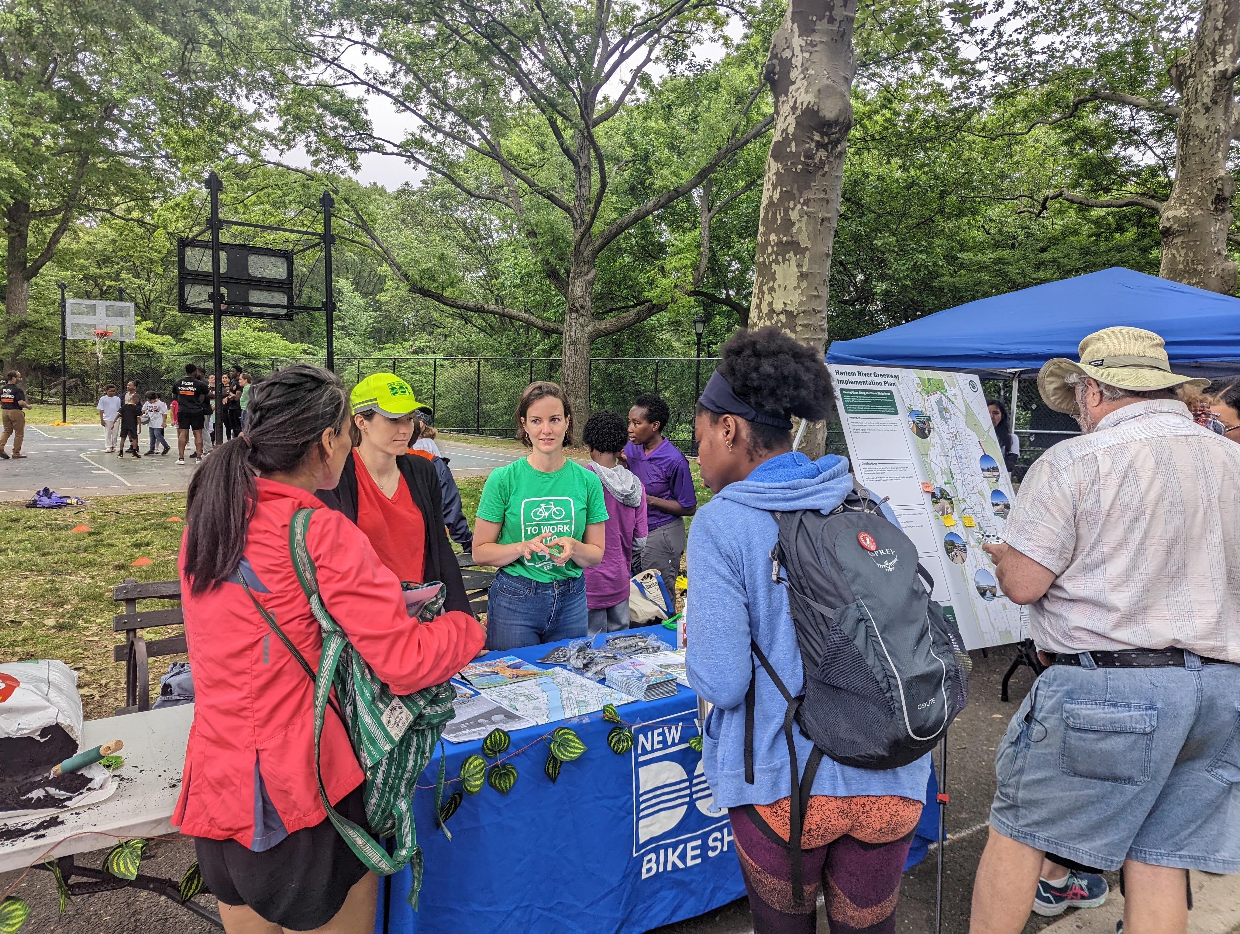 DOT staff talk with community members about the Harlem River Greenway planning process while tabling at a park in the Bronx.