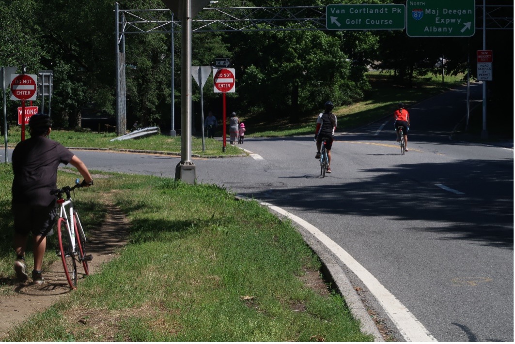 Three cyclists enter Van Cortlandt Park.