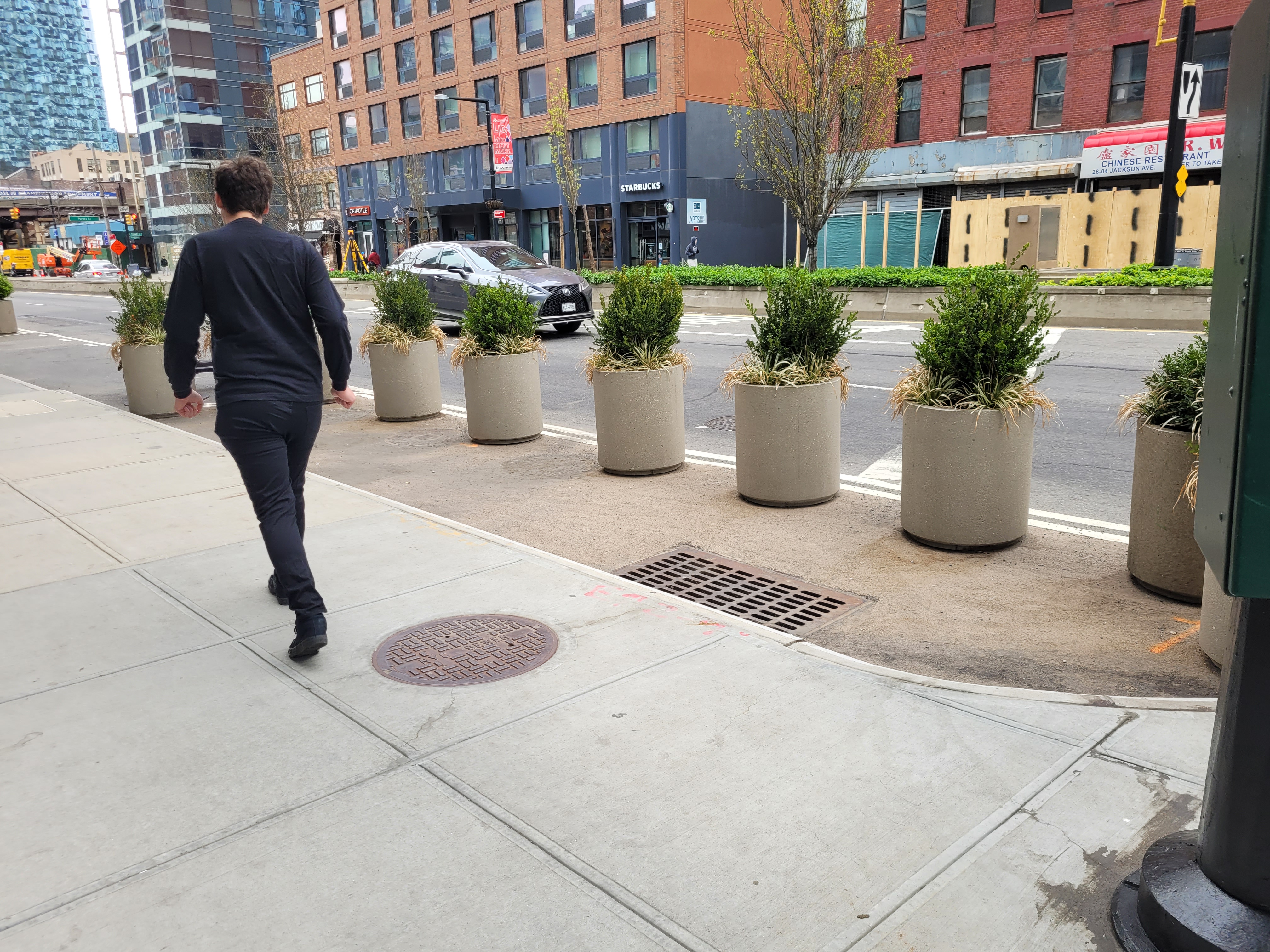 Expanded pedestrian space lined with planters on Jackson Avenue.