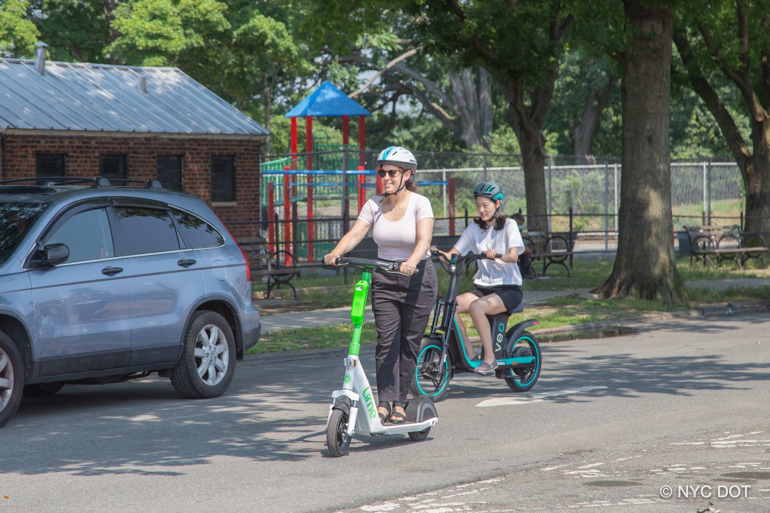 Two people riding e-scooters.