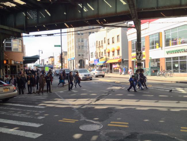 A photo of the intersection of Myrtle/Wyckoff intersection before the plaza. In it, there are crowds of people waiting to cross the street.