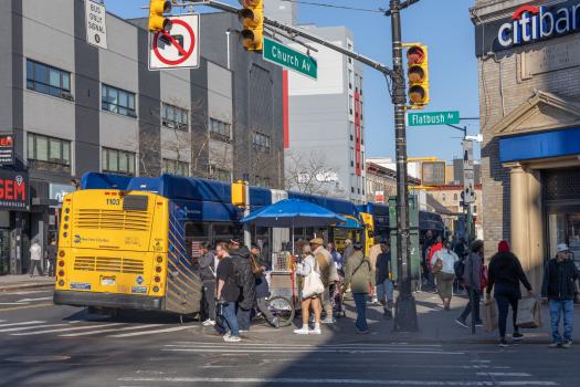 People waiting to cross the street and board the bus at the intersection of Church Av and Flatbush Av