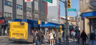 People waiting to cross the street and boarding the bus at the intersection of Church Av and Flatbush Av