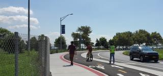 A cyclist rides the greenway near Canarsie Pier as a city worker looks on.