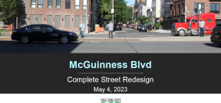 The cover photo of the presentation. Three people stand on the median at McGuinness Blvd at Freeman Street where there is not a crossing.  A dark sedan speeds by in the foreground and a red tractor trailer is parked in the middle of the street in the background.