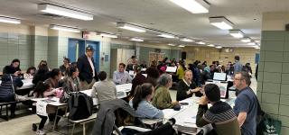 Community members gathered in school cafeteria around tables to discuss 3rd Avenue, Prospect Ave to 62nd St