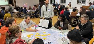 A small group discusses comments regarding the Queens Waterfront Greenway with DOT staff at an October 2024 public workshop.