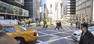 Pedestrians walk to the Park Avenue Medians, a cab drives through the intersection
