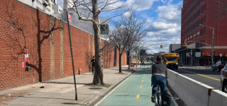A person bikes in a two-way protected bike lane on Vernon Boulevard in Queens.