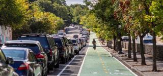 A cyclist rides a two-way protected bike lane on Bailey Ave in the Bronx.